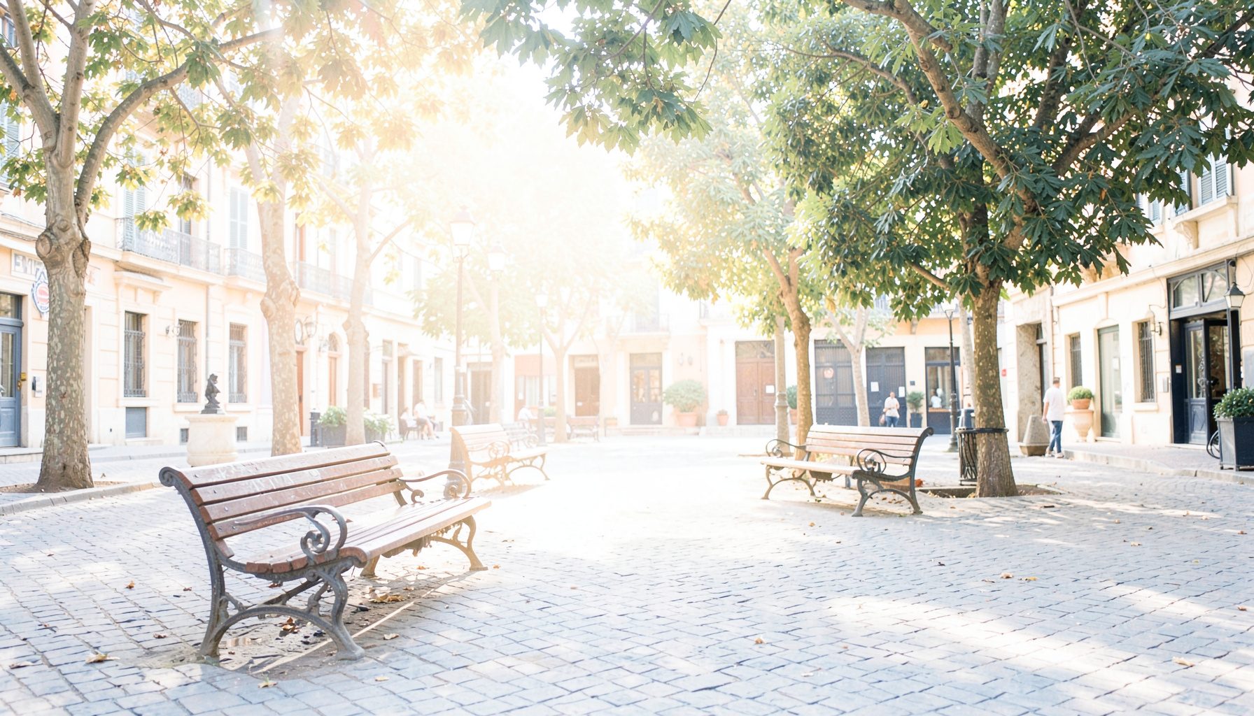 Piazza soleggiata con panchine e alberi, tonalità calde e accoglienti